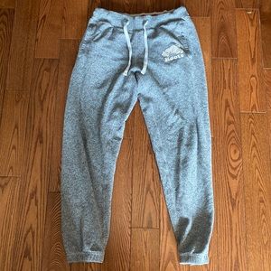 Roots sweatpants with red writing on back and red and white belt around waist